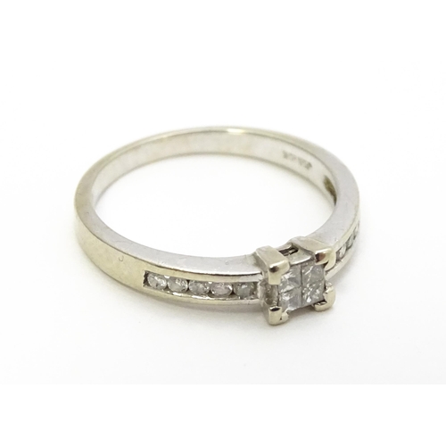 815 - A 9ct white gold ring set with central diamond flanked by further diamonds to shoulders. Ring size a... 