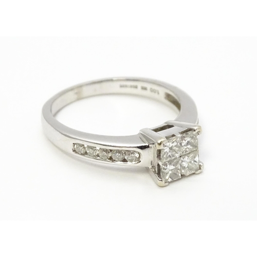 817 - An 18ct white gold ring set with four central diamonds flanked by five further diamonds to each shou... 