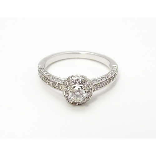 819 - A Bucherer 18ct white gold ring set with central diamond bordered by a profusion of diamonds. With o... 