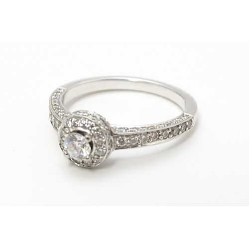 819 - A Bucherer 18ct white gold ring set with central diamond bordered by a profusion of diamonds. With o... 