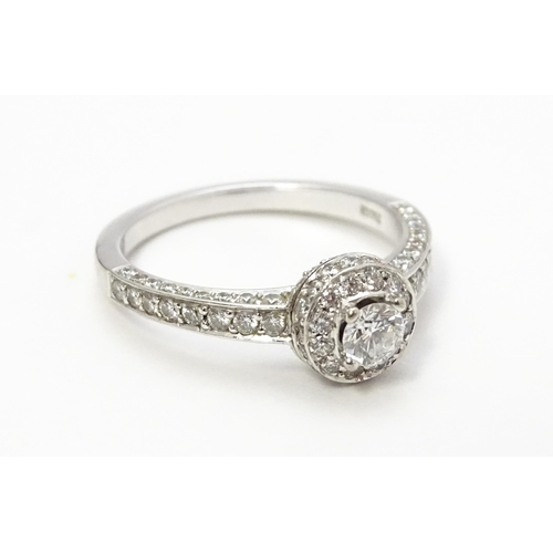 819 - A Bucherer 18ct white gold ring set with central diamond bordered by a profusion of diamonds. With o... 