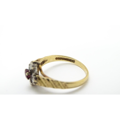 820 - A 9ct gold ring set with central ruby bordered by four diamonds. Ring size approx. M