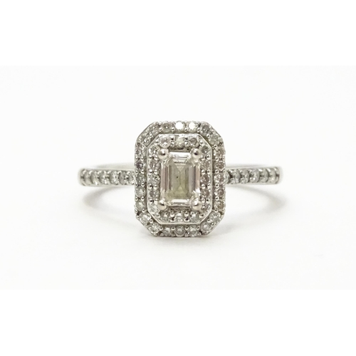 821 - An 18ct white gold ring set with central diamond bordered by two further bands of diamonds and set w... 