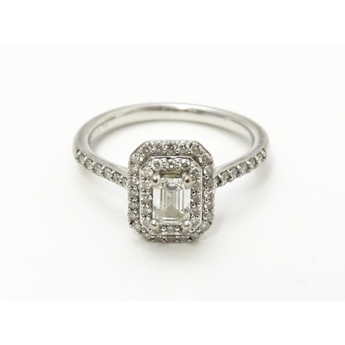 821 - An 18ct white gold ring set with central diamond bordered by two further bands of diamonds and set w... 