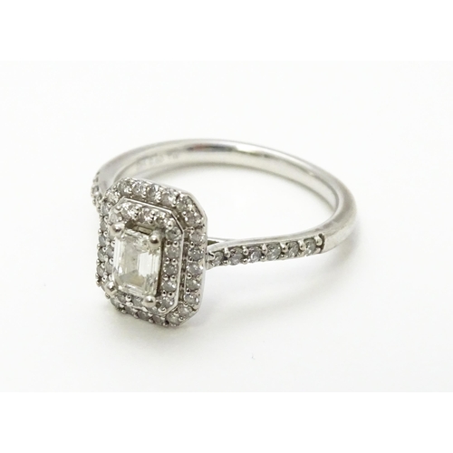 821 - An 18ct white gold ring set with central diamond bordered by two further bands of diamonds and set w... 