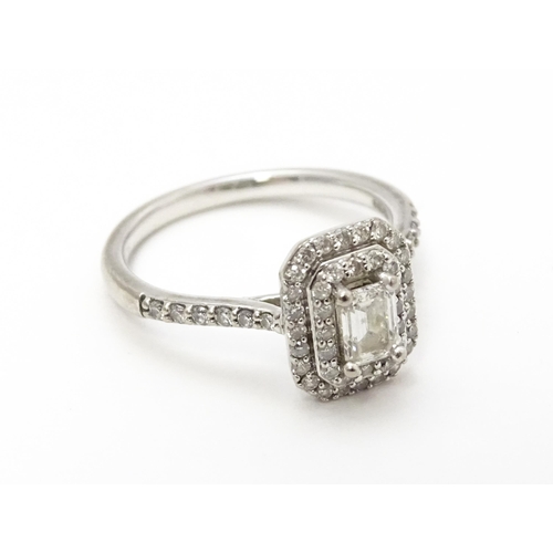 821 - An 18ct white gold ring set with central diamond bordered by two further bands of diamonds and set w... 