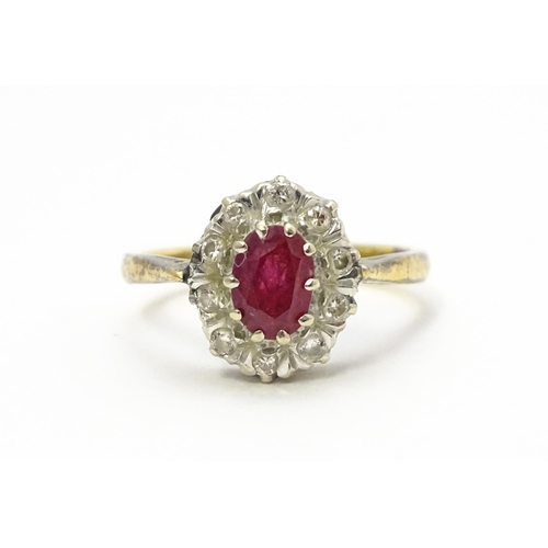 823 - An 18ct gold ring set with central ruby bordered by diamonds. Ring size approx. M