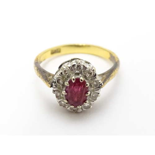 823 - An 18ct gold ring set with central ruby bordered by diamonds. Ring size approx. M