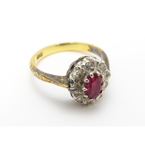 823 - An 18ct gold ring set with central ruby bordered by diamonds. Ring size approx. M