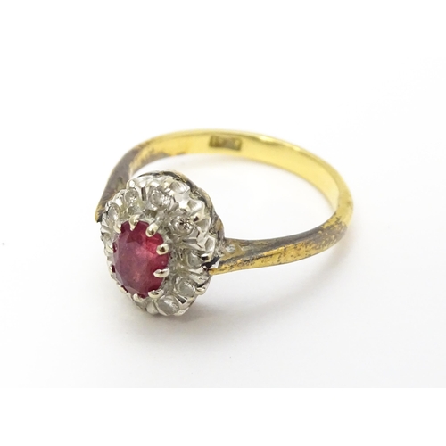 823 - An 18ct gold ring set with central ruby bordered by diamonds. Ring size approx. M