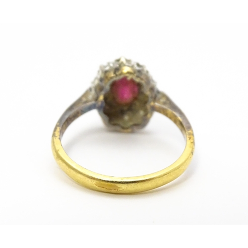 823 - An 18ct gold ring set with central ruby bordered by diamonds. Ring size approx. M