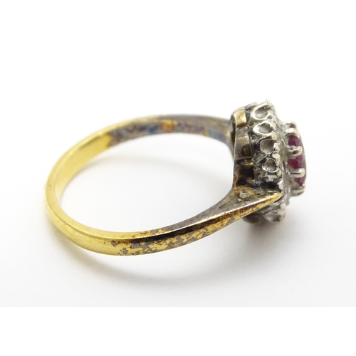 823 - An 18ct gold ring set with central ruby bordered by diamonds. Ring size approx. M