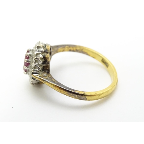 823 - An 18ct gold ring set with central ruby bordered by diamonds. Ring size approx. M