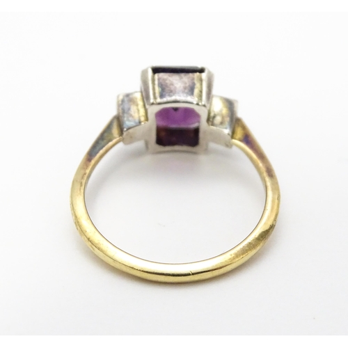 824 - An Art Deco 9ct gold ring with silver set central amethyst coloured stone flanked by white stones, m... 