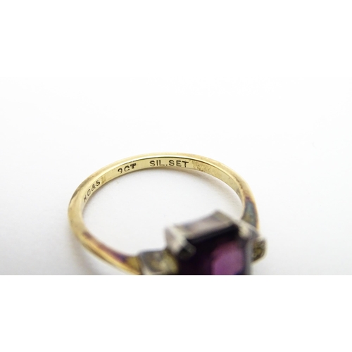 824 - An Art Deco 9ct gold ring with silver set central amethyst coloured stone flanked by white stones, m... 