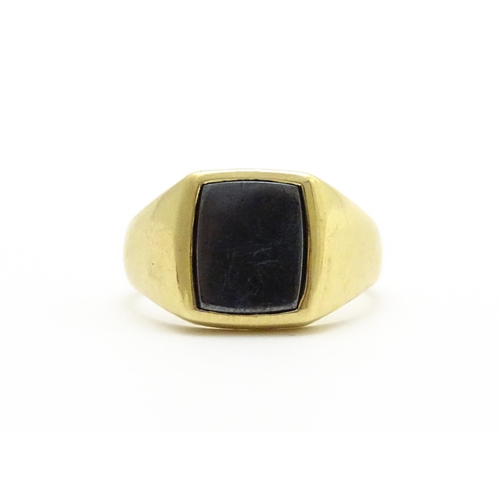 825 - A 9ct gold gentleman's signet ring set with haematite. Ring size approx. U 1/2