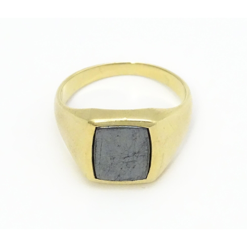 825 - A 9ct gold gentleman's signet ring set with haematite. Ring size approx. U 1/2