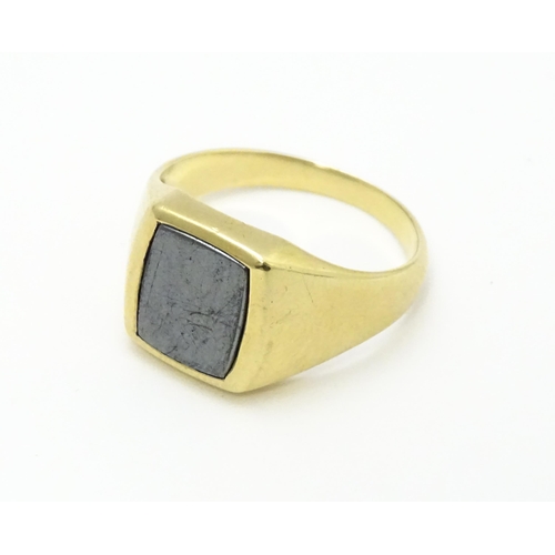 825 - A 9ct gold gentleman's signet ring set with haematite. Ring size approx. U 1/2