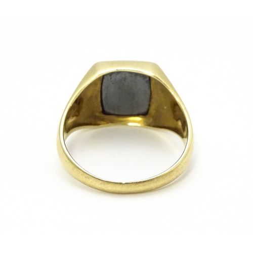 825 - A 9ct gold gentleman's signet ring set with haematite. Ring size approx. U 1/2