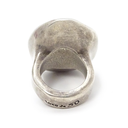 829 - A Spanish white metal dress ring with hammered decoration by Uno de 50. Ring size approx. L