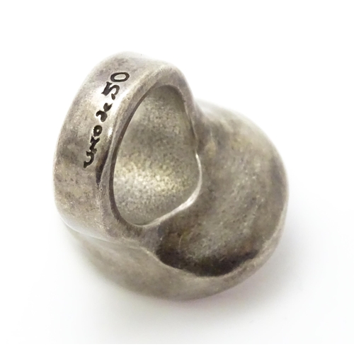 829 - A Spanish white metal dress ring with hammered decoration by Uno de 50. Ring size approx. L