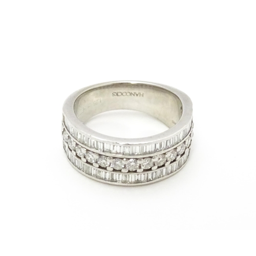 831 - A Hancocks platinum ring set with a profusion of round and baguette cut diamonds. Ring size approx. ... 