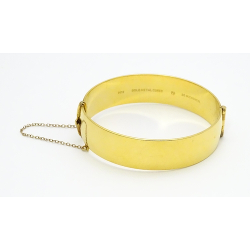 832 - A 9ct gold plated bracelet of bangle form with engraved acanthus scroll detail