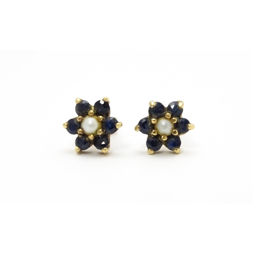 839 - A pair of yellow metal stud earrings with flower detail set with blue stones and pearls