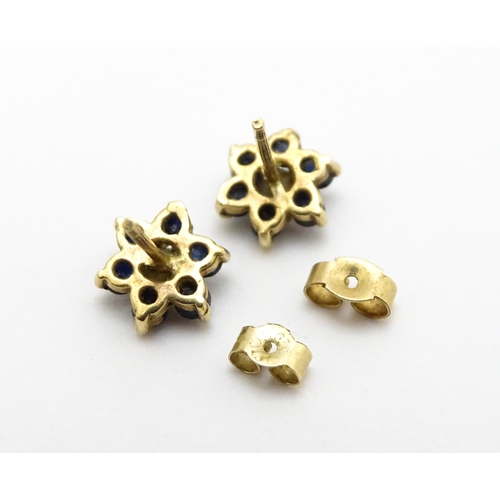 839 - A pair of yellow metal stud earrings with flower detail set with blue stones and pearls