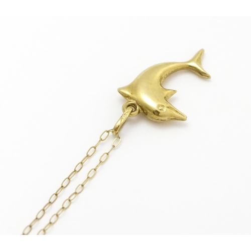 856 - A 9ct gold pendant of dolphin form on a 9ct gold chain. Pendant approx. 1 3/4