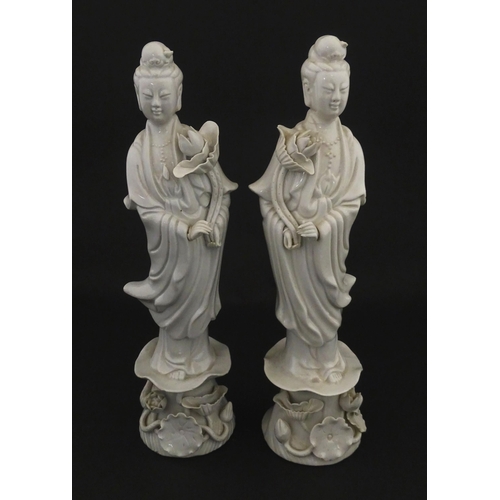 15 - A pair of Chinese blanc de chine figures modelled as Guanyin holding a flower on a lotus base. Appro... 