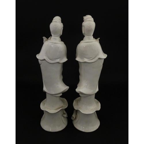 15 - A pair of Chinese blanc de chine figures modelled as Guanyin holding a flower on a lotus base. Appro... 