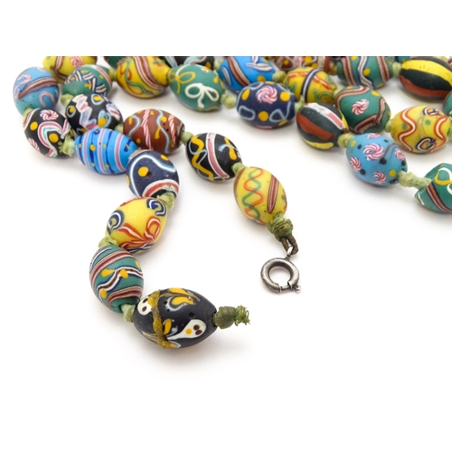 894 - A necklace comprising approximately 42 Venetian glass trade beads of varying designs. Approx. 33