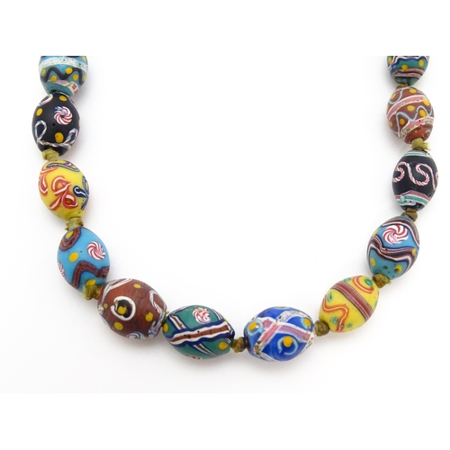 894 - A necklace comprising approximately 42 Venetian glass trade beads of varying designs. Approx. 33