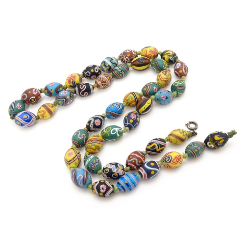 894 - A necklace comprising approximately 42 Venetian glass trade beads of varying designs. Approx. 33