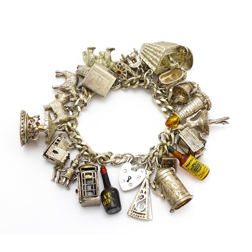 912 - A silver charm bracelet set with various silver and white metal charms to include goat, dog, lightho... 