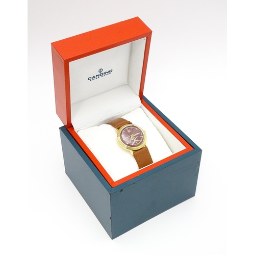 945 - A Candino 3000S wristwatch, the gold plated stainless steel case with a red guilloche enamel dial wi... 