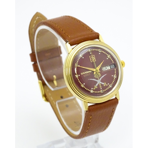 945 - A Candino 3000S wristwatch, the gold plated stainless steel case with a red guilloche enamel dial wi... 