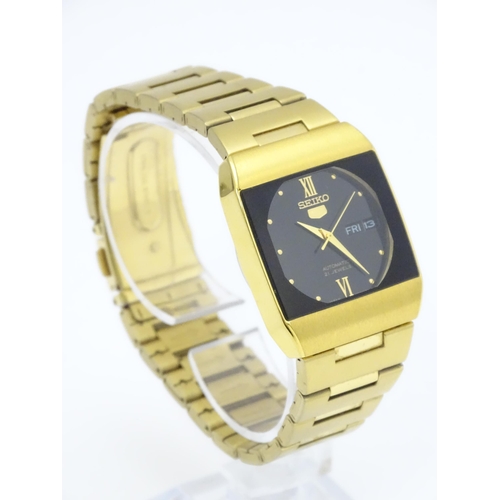 948 - A Seiko 5 gold plated wristwatch with automatic 21 jewel movement, the black dial with day and date ... 