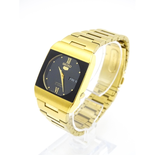 948 - A Seiko 5 gold plated wristwatch with automatic 21 jewel movement, the black dial with day and date ... 