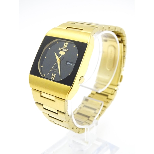 948 - A Seiko 5 gold plated wristwatch with automatic 21 jewel movement, the black dial with day and date ... 