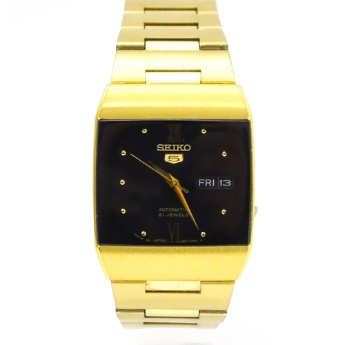 948 - A Seiko 5 gold plated wristwatch with automatic 21 jewel movement, the black dial with day and date ... 