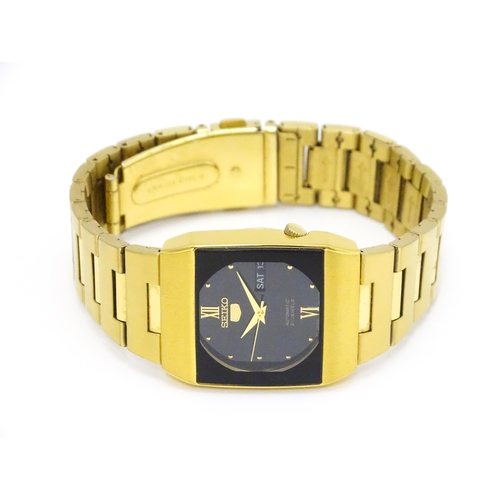 948 - A Seiko 5 gold plated wristwatch with automatic 21 jewel movement, the black dial with day and date ... 