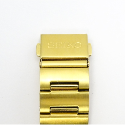 948 - A Seiko 5 gold plated wristwatch with automatic 21 jewel movement, the black dial with day and date ... 