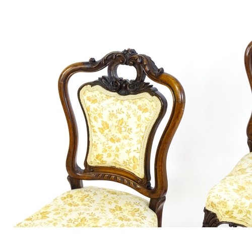 1701 - A pair of mid 19thC rosewood side chairs with acanthus carved top rails above shield shaped, upholst... 