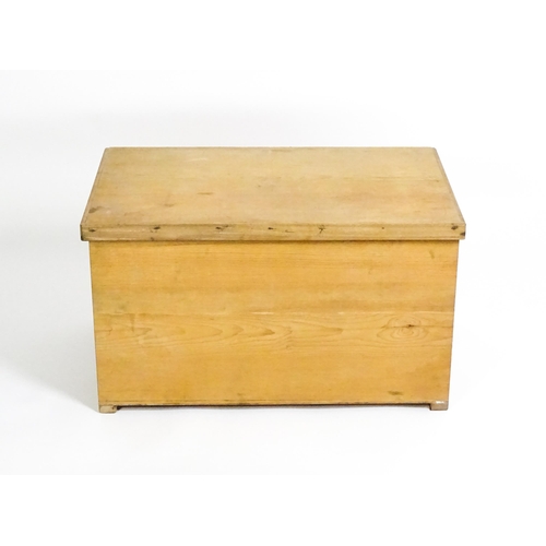 1711 - A 20thC pine trunk with a hinged lid, measuring 31