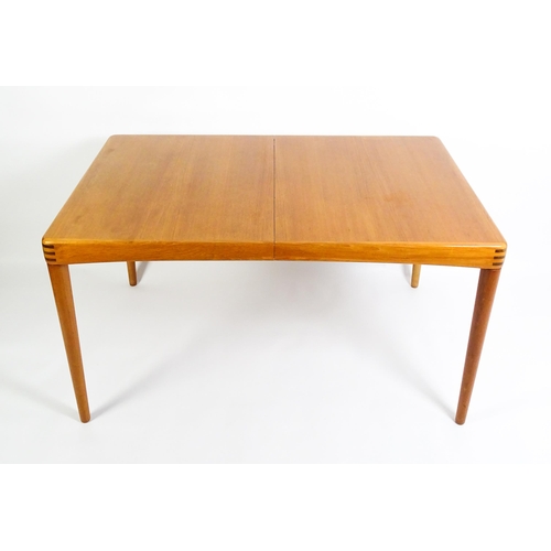 1757 - Vintage / Retro: A mid century extending teak dining table raised on four turned tapering legs and h... 