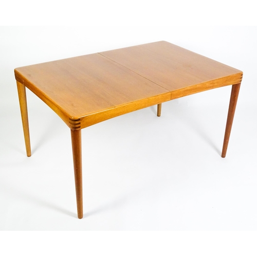 1757 - Vintage / Retro: A mid century extending teak dining table raised on four turned tapering legs and h... 