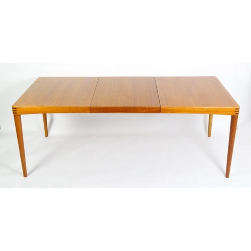 1757 - Vintage / Retro: A mid century extending teak dining table raised on four turned tapering legs and h... 