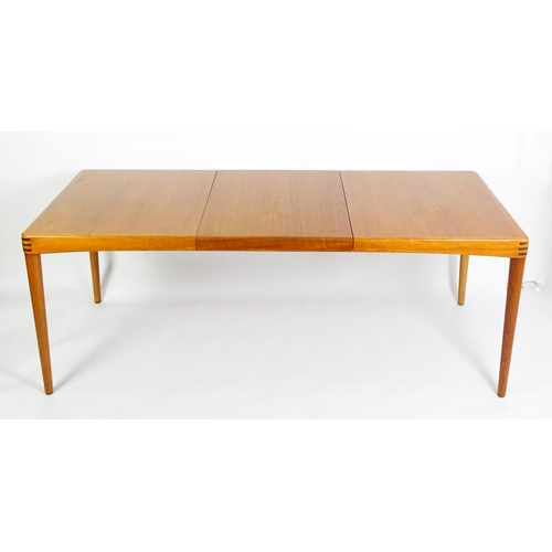 1757 - Vintage / Retro: A mid century extending teak dining table raised on four turned tapering legs and h... 